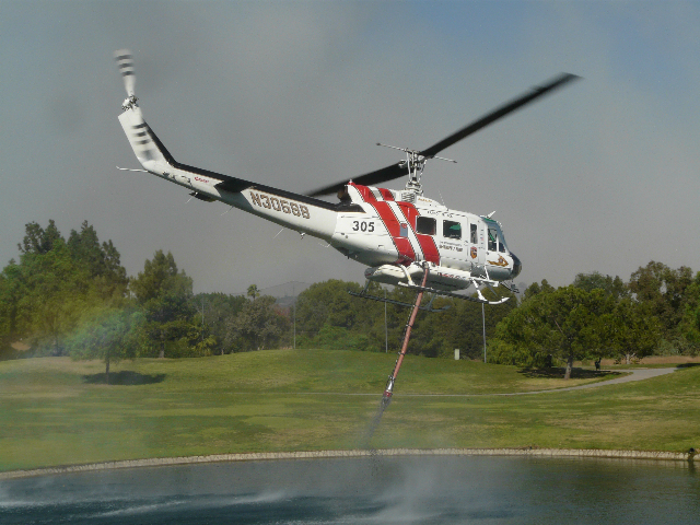 Fire fighting helicopter lifts up from Birch Hills Golf Course lake.