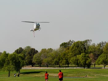 Helecopter used to deliver water to fire approaches Birch Hills Golf Course lake.